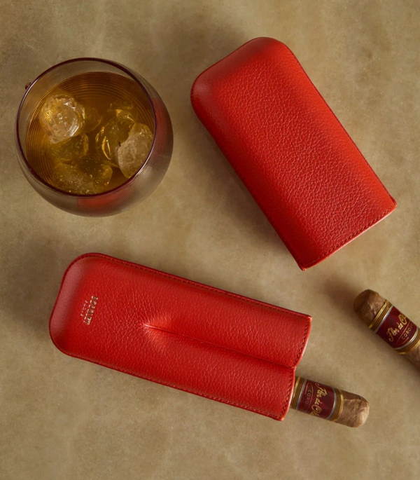 <a href="https://www.abask.com/en-us/products/bosquet-paris-grained-leather-cigar-case-2-cigars-2211352006">BOSQUET PARIS Grained Leather Cigar Case from ABASK, $475</a>