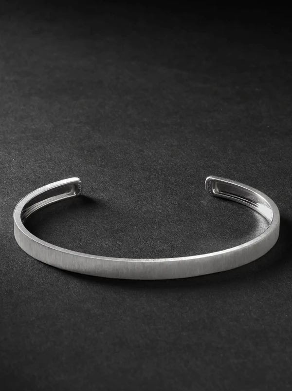 <a href="https://www.mrporter.com/en-us/mens/product/buccellati/fine-jewellery/bracelets/macri-white-gold-cuff/18706561955675919">BUCCELLATI Macri White Gold Cuff from Mr Porter, $5,200</a>