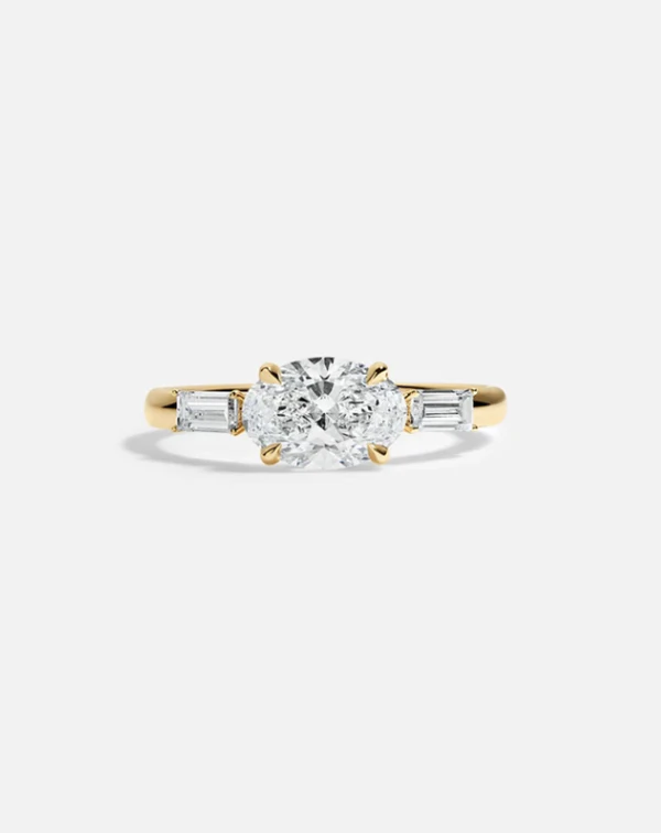 <a href="https://roen.nyc/collections/roen-engagement-rings/products/may-3-stone-ring">Roen</a>