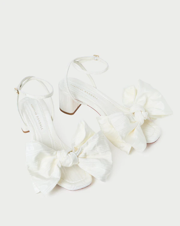 <a href="https://loefflerrandall.com/collections/brides/products/carmen-cream-moire-bow-sandal">LOEFFLER RANDALL Carmen Cream Moiré Bow Sandal</a>, $350
