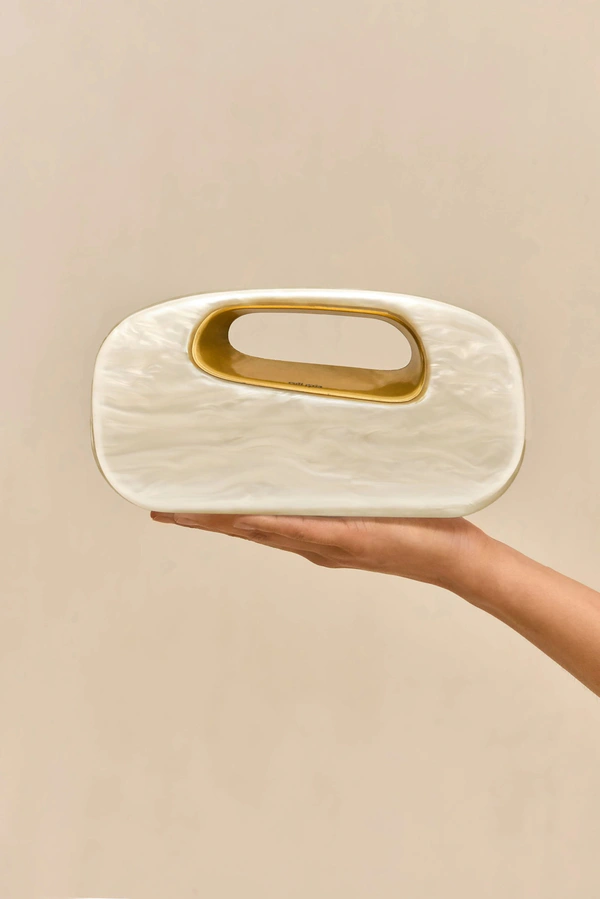 <a href="https://cultgaia.com/products/amara-clutch-ivory">CULT GAIA Bag</a>, $498
