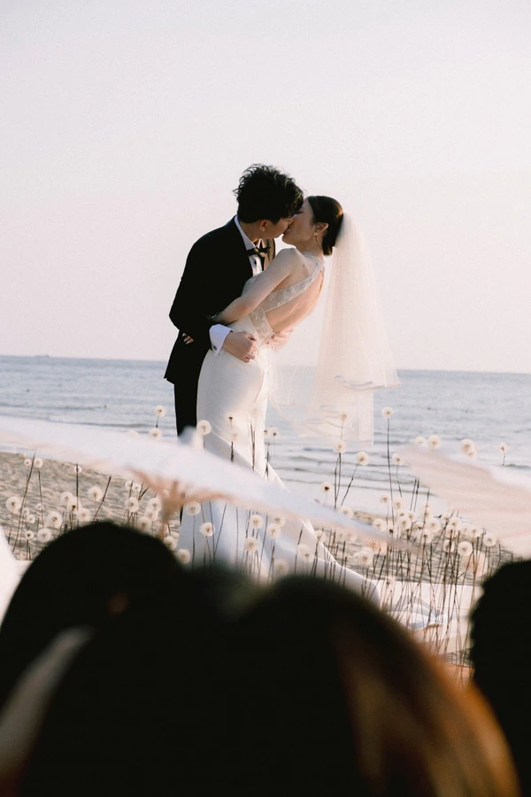 A Cinematic Beach Wedding in Vietnam with a Sunset Ceremony Framed by Dandelions