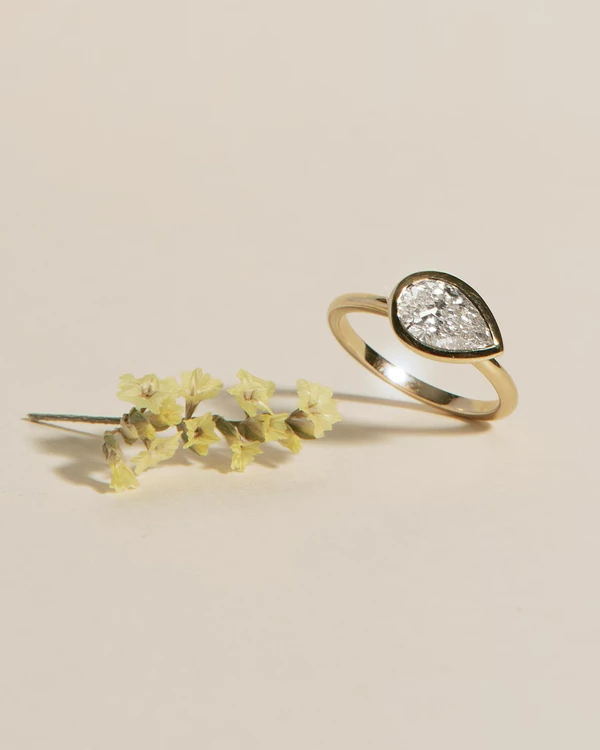 <a href="https://www.vrai.com/engagement-ring/signature-bezel/pear-yellow-gold-39926140993629">VRAI Ring</a>, $1,265