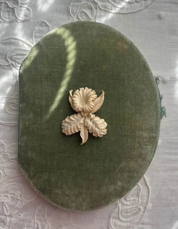 <a href="https://www.luciazolea.com/new-arrivals/vintage-celluloid-orchid-rhinestone-cabochon-brooch">Lucia Zolea</a>