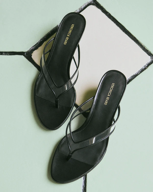 <a href="https://veronicabeard.com/products/clea-jelly-wedge-sandal-clear-black?_gl=1*15np3xr*_up*MQ..*_gs*MQ..&gclid=CjwKCAjwmdLSBhANEiwAkREMN26G_u0hB2ZD3QhE_45LE-4BYHGZlUAOuFj9Z7NcU6bC7wd7XhMLjRoC27QQAvD_BwE&gbraid=0AAAAABMxaq_OYvDvi3-otrusGoQrepbkr">VERONICA BEARD Clea Jelly Wedge Sandal</a>, $375