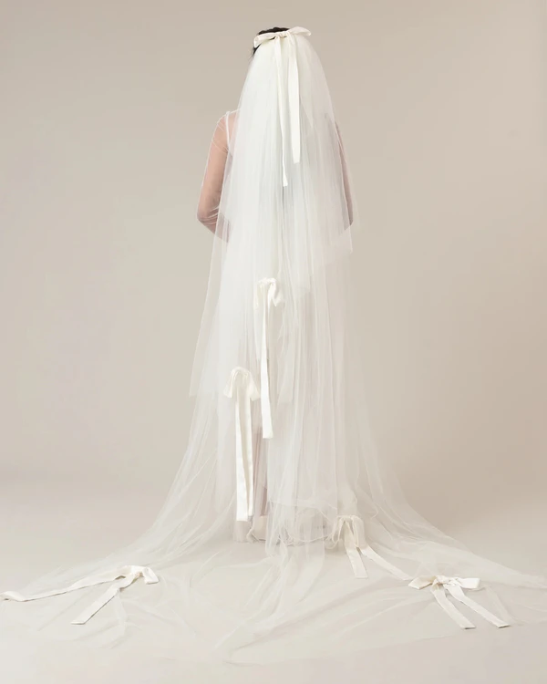 <a href="https://ofrendastudio.com/products/nina-satin-bows-three-tier-veil-veil">Ofrenda Studio</a>