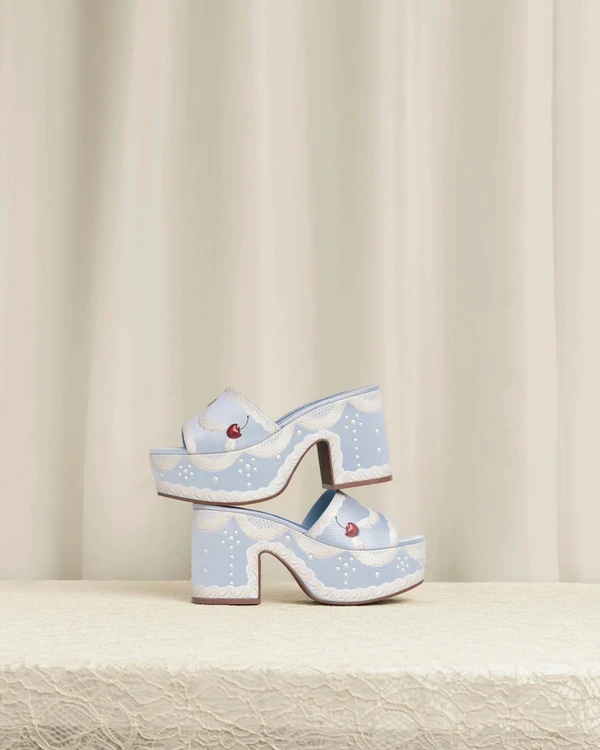 <a href="https://larroude.com/products/blue-dolly-cake-lace-sandal-satin?_pos=1&_sid=d573a51b0&_ss=r">LARROUDÉ x TANNER FLETCHER Miso Cake Mule</a>, $350