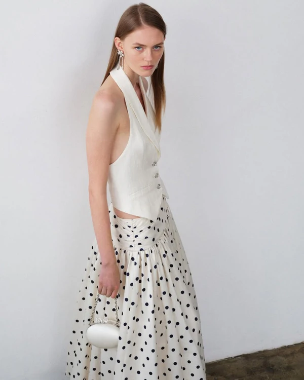 <a href="https://us.self-portrait.com/products/pf26-cream-linen-blend-waistcoat?_gl=1*q9lygu*_up*MQ..*_ga*NDcxNzcxNTQyLjE3ODA0NzA3OTk.*_ga_2EK45EZ9KD*czE3ODA0NzA3OTkkbzEkZzAkdDE3ODA0NzA4MDckajUyJGwxJGgzNTIxOTU0NjM.">SELF-PORTRAIT Waistcoat</a>, $410, <a href="https://us.self-portrait.com/products/pf26-cream-polka-dot-taffeta-midi-skirt?cts=1&amp;_gl=1*1sa5otj*_up*MQ..*_ga*NDcxNzcxNTQyLjE3ODA0NzA3OTk.*_ga_2EK45EZ9KD*czE3ODA0NzA3OTkkbzEkZzEkdDE3ODA0NzA4MjkkajMwJGwxJGgzNTIxOTU0NjM.">SELF-PORTRAIT Skirt</a>, $560