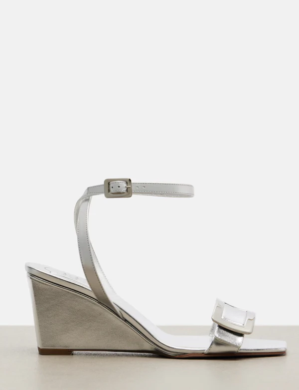 <a href="https://www.mytheresa.com/us/en/women/roger-vivier-belle-vivier-metallic-leather-sandals-silver-p01140934?dplink=true&amp;utm_source=sea_pla&amp;utm_medium=google&amp;utm_campaign=google_sea&amp;chn=sea_shopping&amp;src=google&amp;cmp=22079385109&amp;tarea=us&amp;tar=&amp;ag=&amp;ptyp=&amp;feed_num=P01140934-6&amp;gclid=CjwKCAjw_KjVBhAHEiwAnC0N9OtJTyCVhZeKnv8pUmdKjaHFlH3J5_yxMeNGJuuZ1DTBXrV5ceLJyxoCacgQAvD_BwE&amp;gbraid=0AAAAAD3Pw-kR5kvE8mWYxVORdKpaXj7Fp&amp;gad_source=1&amp;gad_campaignid=22079393959&amp;gbraid=0AAAAAD3Pw-kR5kvE8mWYxVORdKpaXj7Fp&amp;slink_id=ecc83ea2-a977-4e29-ad67-d8889941de53&amp;slink=1">ROGER VIVIER Metallic Wedge Sandals from Mytheresa, $1,295</a>